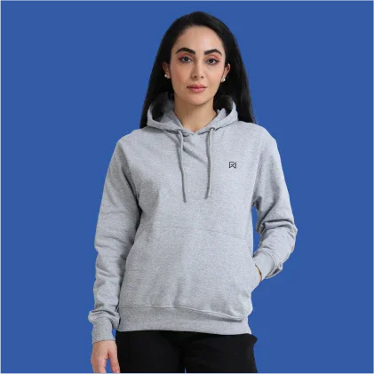 Woman wearing light gray pullover hoodie with front pocket on blue background